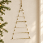 Sapin de Noël suspendu en fer forgé sur un mur clair dans un intérieur festif